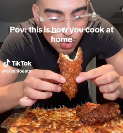 A man enjoying a meal with a crispy chicken wing